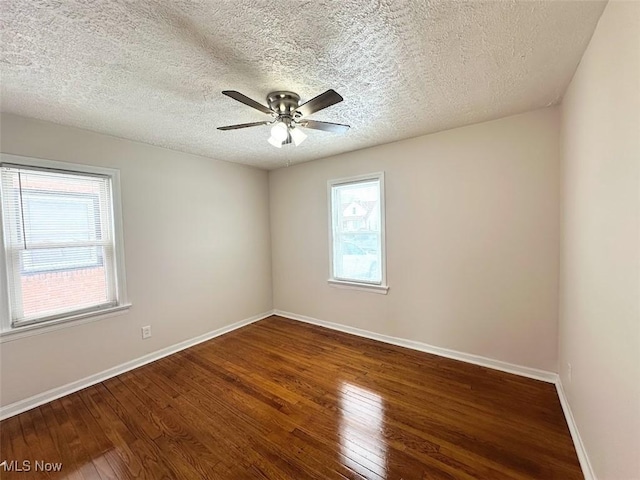 unfurnished room featuring a textured ceiling, hardwood / wood-style floors, a ceiling fan, and baseboards