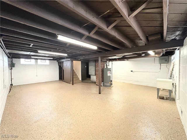 basement with a sink, stairs, and gas water heater