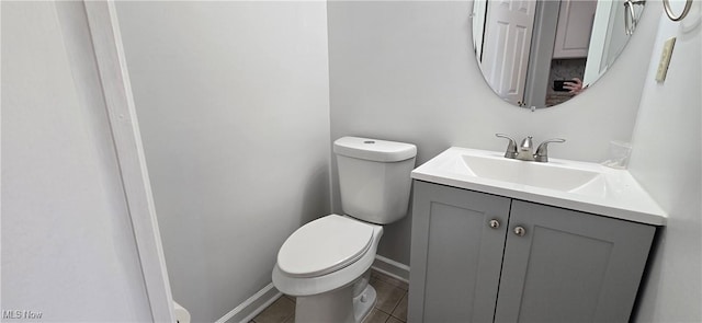 bathroom featuring baseboards, vanity, toilet, and tile patterned floors