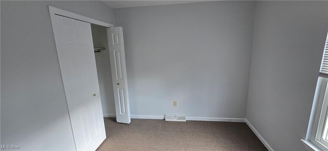 unfurnished bedroom with carpet floors, baseboards, visible vents, and a closet