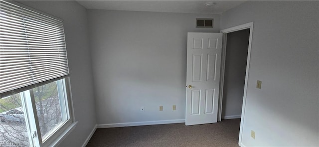 carpeted spare room with visible vents and baseboards