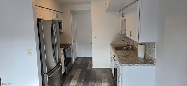 kitchen with baseboards, decorative backsplash, appliances with stainless steel finishes, dark wood-style flooring, and a sink