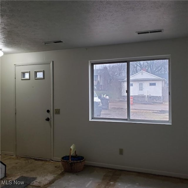 entrance foyer featuring a healthy amount of sunlight, visible vents, and a textured ceiling