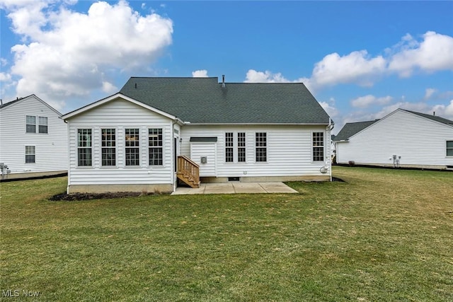 rear view of house with entry steps, a patio area, a lawn, and roof with shingles