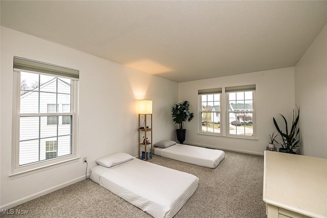 bedroom with multiple windows, carpet flooring, and baseboards