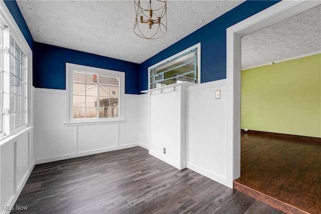 interior space with a textured ceiling, wood finished floors, and an inviting chandelier