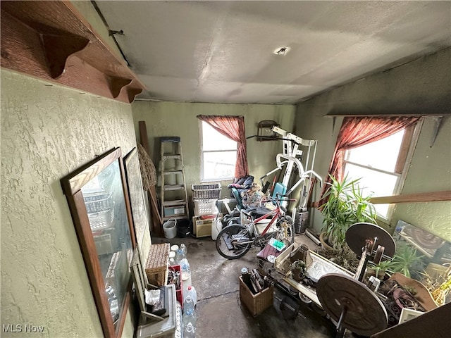 misc room with concrete flooring and a textured wall