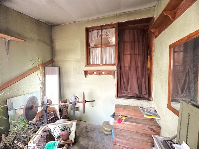 misc room with concrete floors and a textured wall