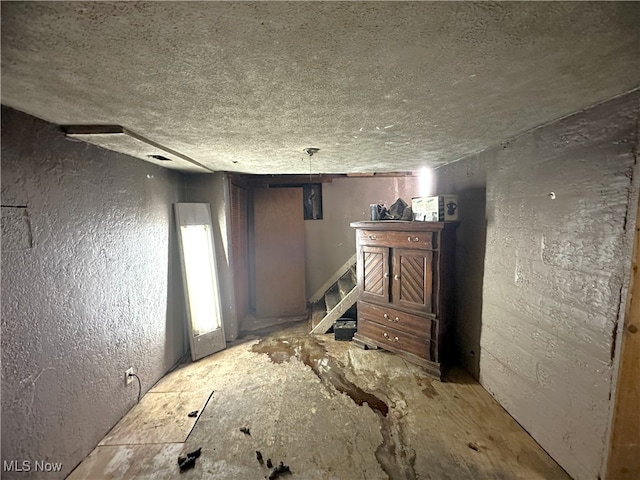 interior space with stairs, a textured wall, and a textured ceiling