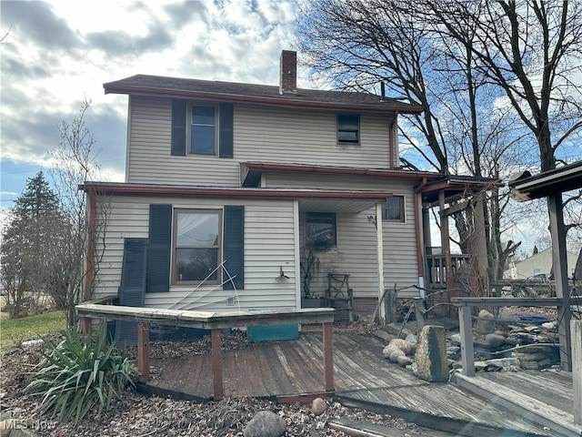 rear view of property featuring a deck and a chimney