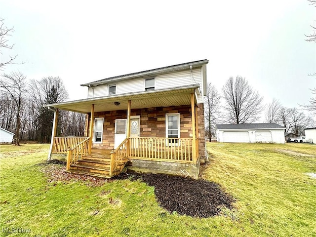 view of front facade featuring covered porch, a front yard, a garage, stone siding, and an outdoor structure