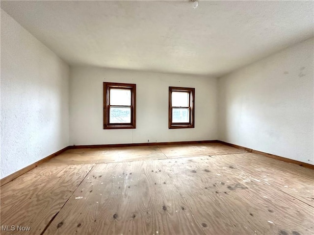 unfurnished room with baseboards