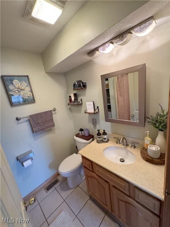 bathroom with tile patterned flooring, visible vents, toilet, and vanity