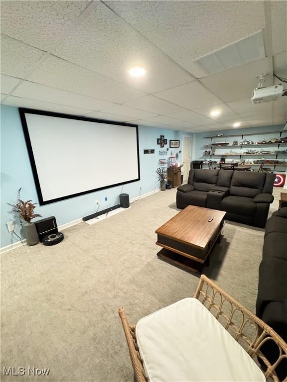 carpeted cinema with baseboards and a drop ceiling