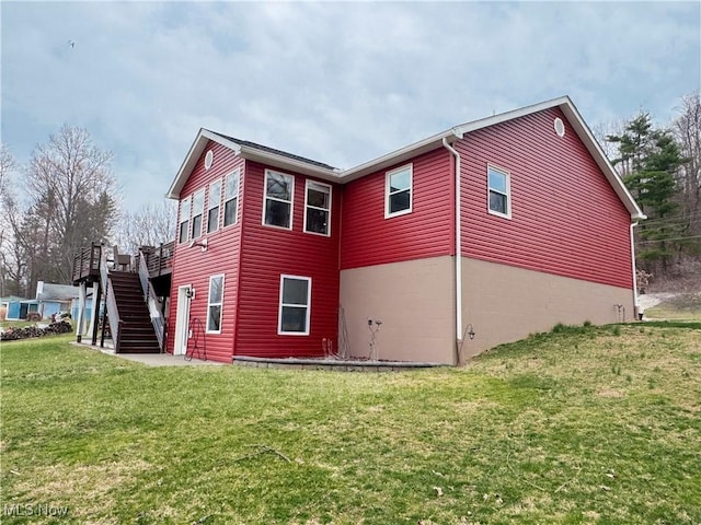 back of property featuring a wooden deck, stairs, and a yard