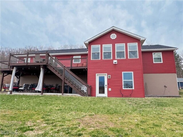 back of house featuring stairway, a patio, a lawn, and a deck
