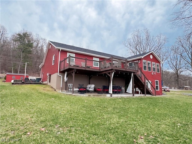 rear view of property featuring stairway, a lawn, and a wooden deck