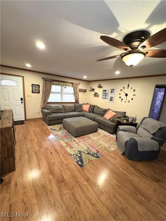 living area with baseboards, ornamental molding, recessed lighting, light wood-style flooring, and a ceiling fan