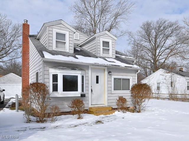 new england style home with a garage and a chimney