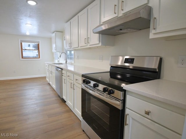 kitchen featuring light countertops, light wood-style flooring, appliances with stainless steel finishes, white cabinetry, and under cabinet range hood