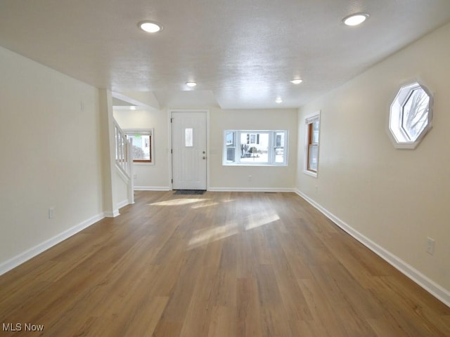 foyer featuring stairs, recessed lighting, baseboards, and wood finished floors