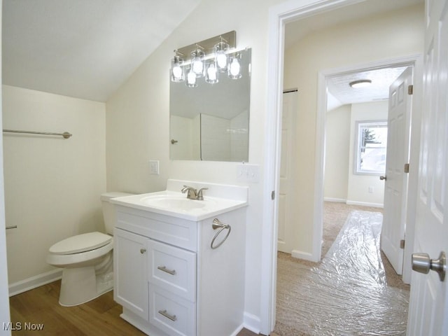 bathroom featuring lofted ceiling, vanity, toilet, and baseboards