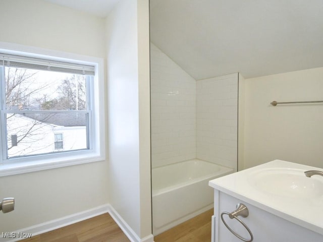 full bath with lofted ceiling, vanity, baseboards, and wood finished floors