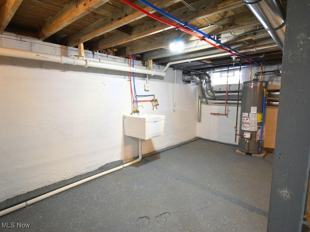 below grade area featuring a sink and gas water heater