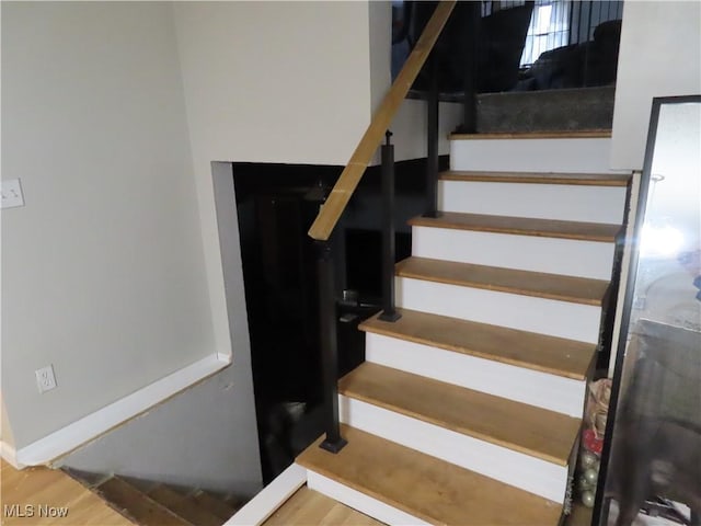 stairs featuring baseboards and wood finished floors