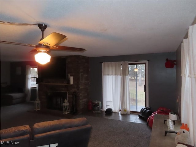 living room featuring a brick fireplace and a ceiling fan