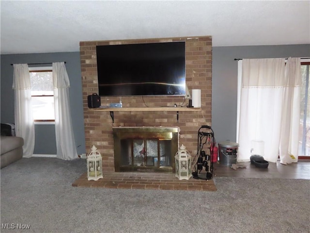 living room featuring a brick fireplace and carpet flooring