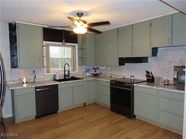 kitchen featuring under cabinet range hood, range with electric stovetop, a sink, light wood-style floors, and black dishwasher