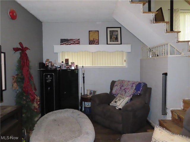 living area featuring vaulted ceiling and stairway