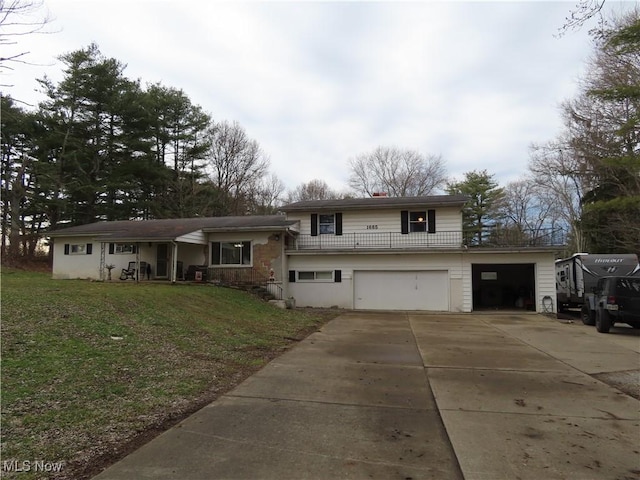 tri-level home with driveway, an attached garage, and a front lawn