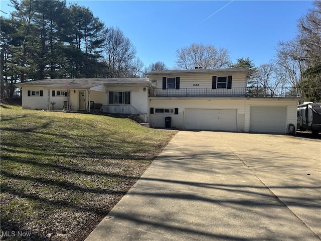 split level home featuring a front yard, a garage, and driveway