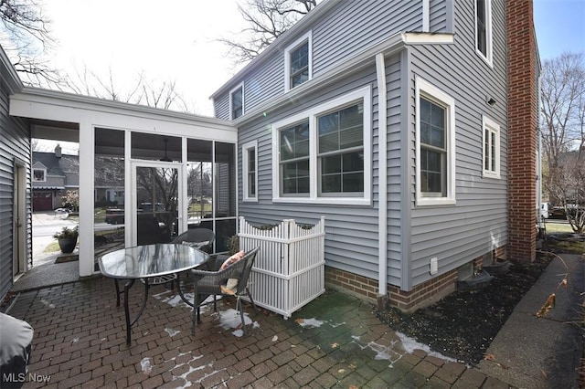 view of property exterior featuring a patio and a sunroom