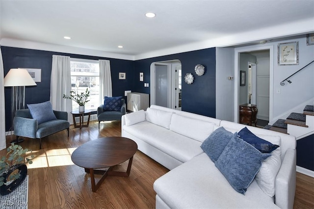 living area with stairway, arched walkways, dark wood-type flooring, and recessed lighting