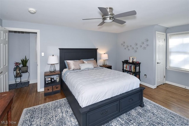 bedroom with dark wood-style floors, ceiling fan, and baseboards