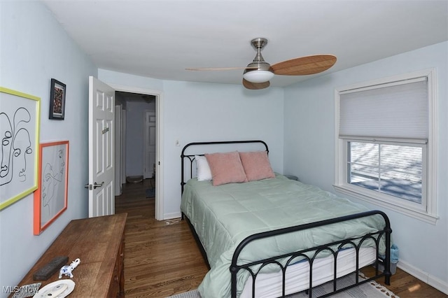 bedroom with ceiling fan, baseboards, and wood finished floors