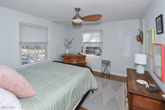 bedroom featuring wood finished floors, a ceiling fan, and baseboards