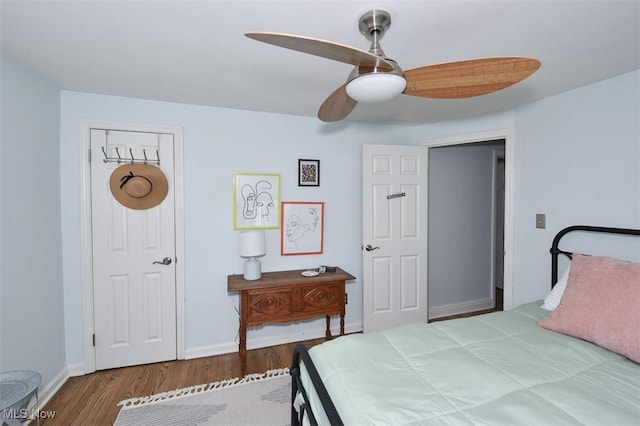 bedroom with a ceiling fan, baseboards, and wood finished floors