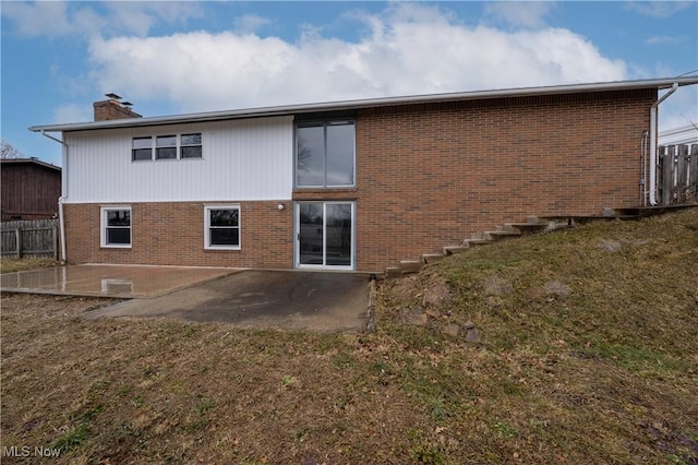 back of house with brick siding, a patio area, and fence