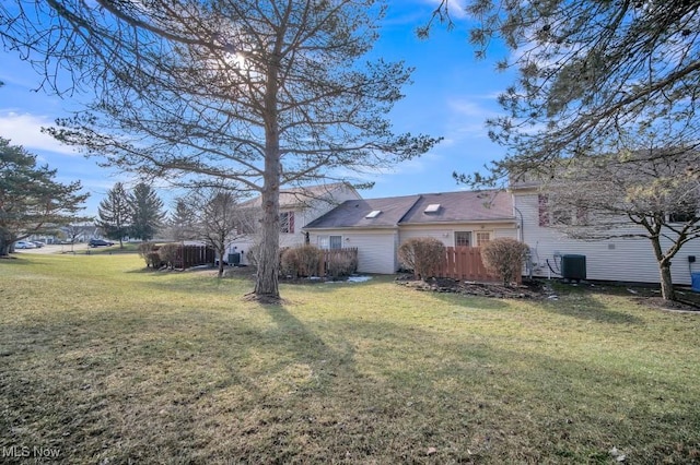 rear view of house with a yard and central AC