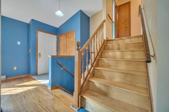 stairway featuring wood finished floors and baseboards