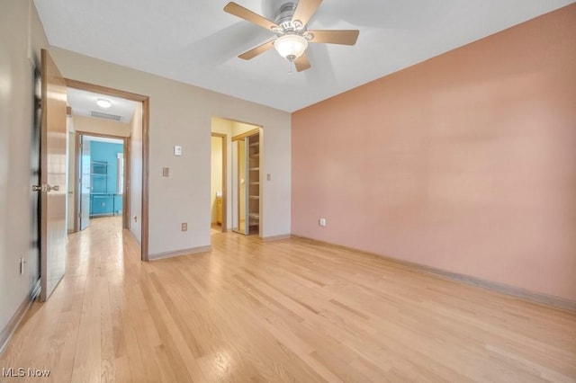 empty room with light wood finished floors, ceiling fan, and baseboards