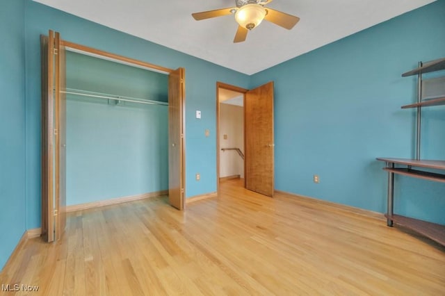 unfurnished bedroom with a ceiling fan, a closet, baseboards, and wood finished floors