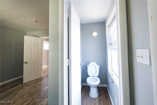 bathroom featuring toilet, baseboards, and wood finished floors