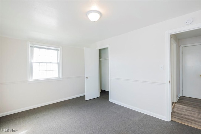 unfurnished bedroom with a closet, carpet flooring, and baseboards