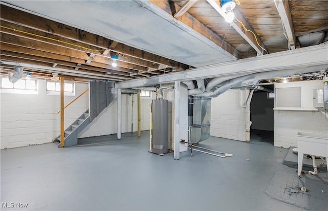 basement featuring gas water heater, electric panel, heating unit, and stairs