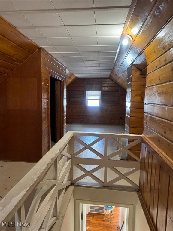 bonus room featuring wood walls and vaulted ceiling